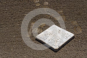 Close up of baseball base plate on a freshly groomed dirt field