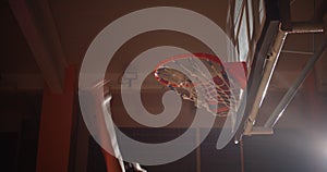 Close-up basket basketball ball slam dunk caucasian player jump ray of light