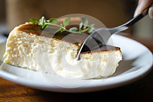 Close Up,Basque Burnt Cheesecake,Tarta de Queso or San Sebastian Cheesecake on a white plate with a spoon to scoop the soft cheese photo