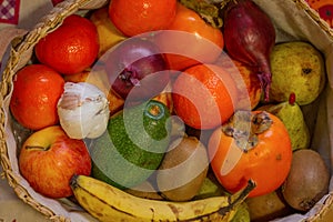 Close up view of basquet full of fruits and a head of garlic. photo