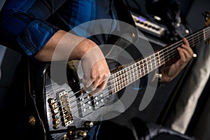 Close-up of bassist`s hands playing bass guitar