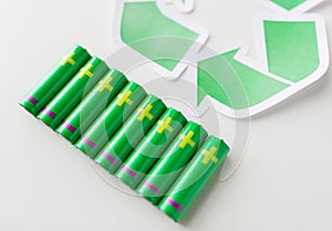 Close up of batteries and green recycling symbol