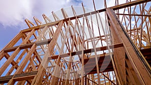 Close-up of beam built home under construction and blue sky with wooden truss, post and beam framework. Timber frame house, real