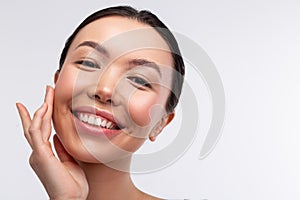 Close up of beaming dark-haired woman smiling broadly