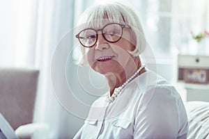 Close up of beaming elegant elderly lady smiling after family day