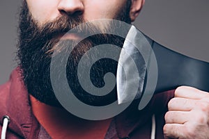 Close up of beard Confident young bearded man carrying a big axe