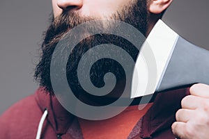 Close up of beard Confident young bearded man carrying a big axe on shoulder