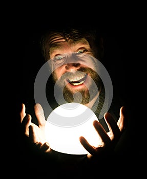 Close-up of a bearded man expresses various emotions on a black background, holding a lamp in front of himsalf