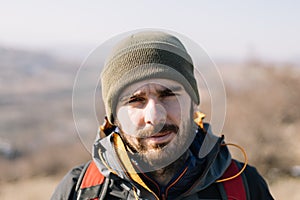 Close-up of a bearded traveler man with green hat