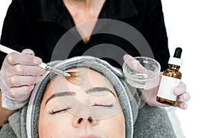 Close up of beautician cosmetologist applying chemical peel treatment on patient in a beauty spa, for skin rejuvenation,