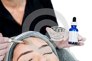 Close up of beautician cosmetologist applying chemical peel treatment on patient in a beauty spa, for skin rejuvenation,