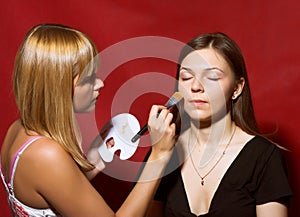 Close up of beautician creating makeup for a young women