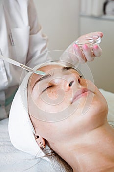 Close-up beautician doctor hand making anti-age procedure apply peeling acid