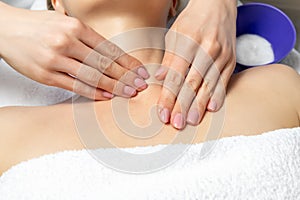 Close-up beautician doctor hand making anti-age procedure, mask and peeling for young attractive female client at beauty