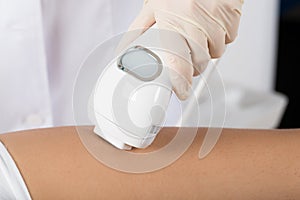 Close-up of beautician giving epilation laser treatment