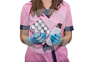 Close-up of a beautician holding an ultrasound apparatus and a pack of masks for cosmetic procedures