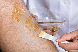 Beautician Waxing Man`s Leg