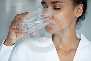 Close up beautiful African American woman drinking pure water