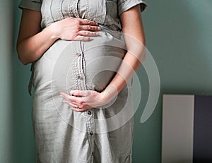 Close up of a beautiful big belly from a pregnant woman in dress. Pregnancy and motherhood concept.