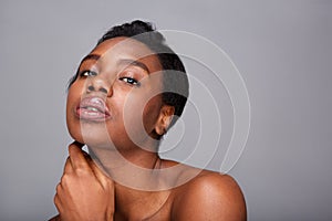 Close up beautiful black woman with hand to face and bare shoulders