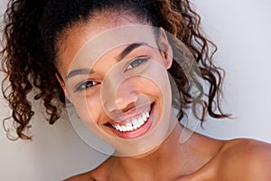 Close up beautiful black woman smiling against white wall