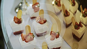 Close up of Beautiful, bright buffet with many sweet snacks, a candy bar, is on a white table.