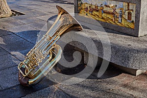 Close-up of a beautiful and bright tuba resting on a stone bench with ornament in Toledo, Spain