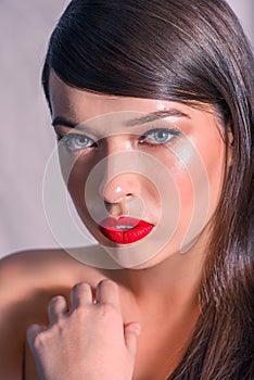 Close-up of a Beautiful Caucasian Woman With Cat Blue Eyes, Full Red Lips and Open Mouth, Touching Her Shoulder, on Grey