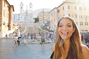 Close up of beautiful cheeful woman in Piazza di Spagna square in Rome with Spanish Steps and Barcaccia fountain on the background