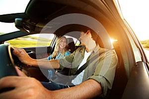 Close up beautiful couple laughing in car on road trip