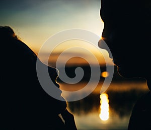 Close-up of beautiful emotional bride holding face of handsome groom, newlywed couple looking into each other eyes