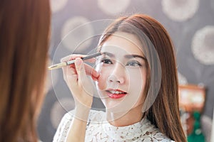 Close up of beautiful face of young woman getting make-up on her