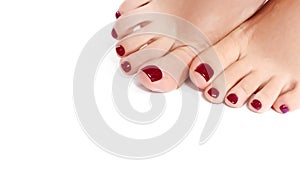 Close-up Beautiful Female Feet with Red Pedicure. Clean Soft Skin, Healthy Nails with Gel Polish. Copy Space on White