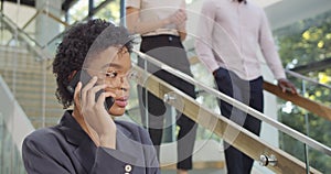 Close up of beautiful girl office manager talking on mobilephone and smiliing . Young african businesswoman having