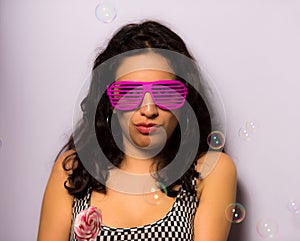 Close up of a beautiful girl with professional make-up blowing soap bubbles around her