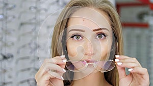 Close-up of a beautiful green-eyed girl wearing stylish glasses for vision correction. The girl wears thin-rimmed