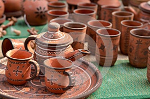 Close up of beautiful Gujarati Khavda Pottery earthen decorated terracotta crockery tea cups, kettle and tray with glasses at a