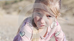 Close-up of a beautiful little sad girl, with big blue galas