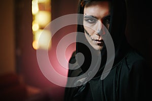 Close-up of a beautiful man`s face with Halloween make-up.