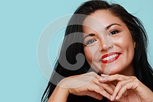 Close-up of beautiful mature woman with beautiful smile. Isolated on blue background wall.