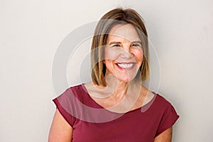 Close up beautiful middle age woman smiling against white wall photo