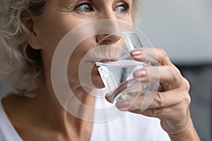 Close up beautiful middle aged woman drinking pure mineral water