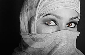 Close-up beautiful mysterious eyes eastern woman wearing a hijab. black and white