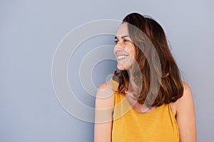 Close up beautiful older woman smiling against gray wall