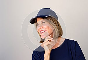 Close up beautiful older woman smiling with her against gray wall