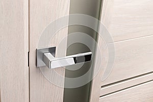 Close up of beautiful and stylish new metal door knob on modern interior door.