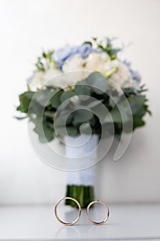 Close up of a beautiful, stylish two gold rings on wedding bouquet. Selective focus.