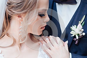 Close-up of beautiful wedding couple in park. They kiss and hug each other