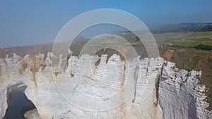 Close-up of beautiful white cliff and people walking on the top in the morning fog. Action. Picturesque view from the