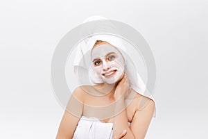 Close-up beautiful woman applying moisturizer cosmetic cream on face on light background.